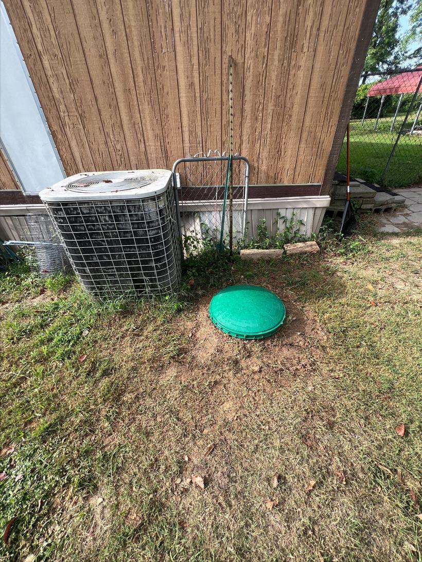 Septic tank riser lid set at ground level in a Central Arkansas back yard